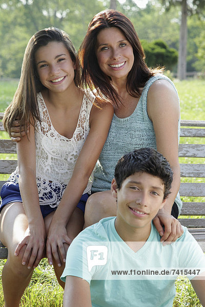Outdoor portrait of smiling mother with daughter (12-13) and son (14-15)