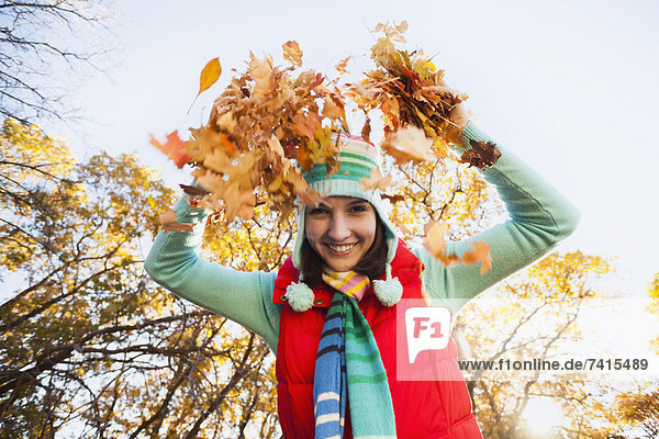 junge Frau junge Frauen Portrait werfen lächeln Wald Herbst trocken