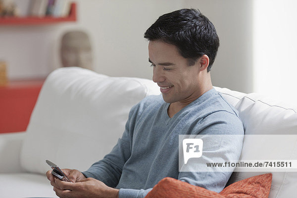 Man texting in living room