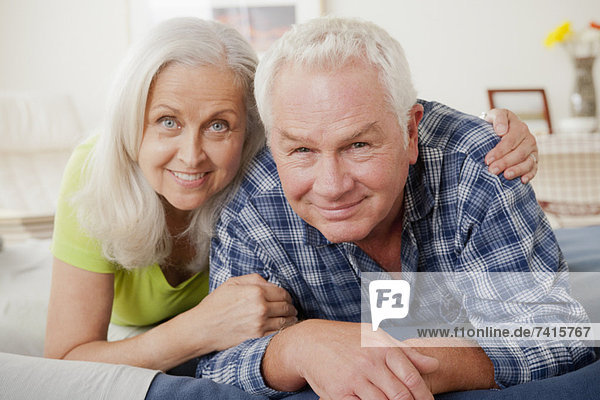 Portrait of senior couple laying on bed