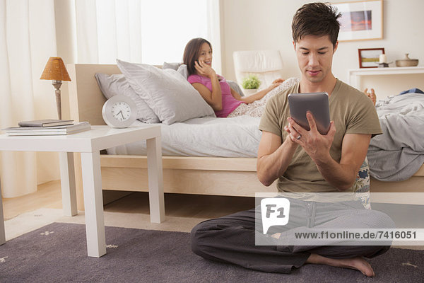 Couple using mobile phone and digital tablet