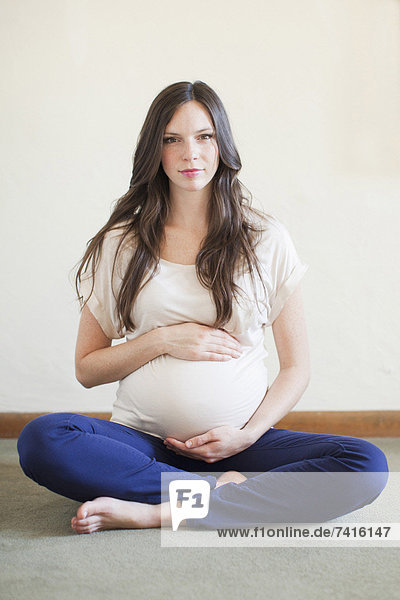 sitzend  überqueren  Portrait  Frau  berühren  Schwangerschaft  Mittelpunkt  Erwachsener