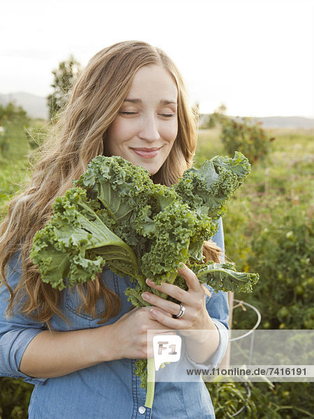 Portrait of young woman holding kale