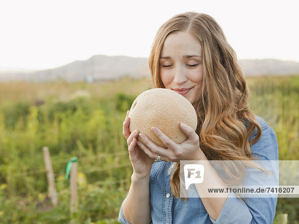 Portrait of young woman holding cantaloupe