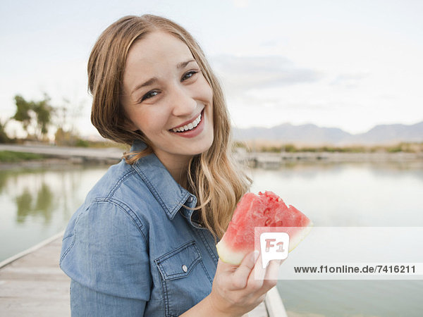 Portrait of young woman eating watermelon