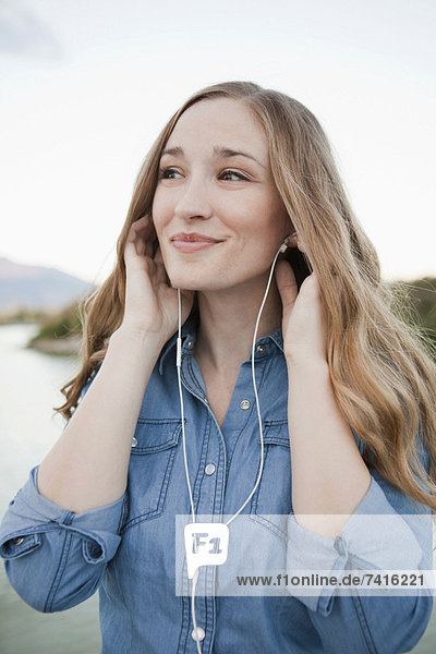 Portrait of young woman listening to mp3 player