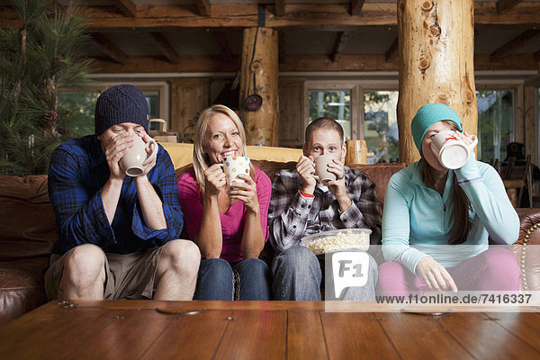 Friends drinking tea in log cabin