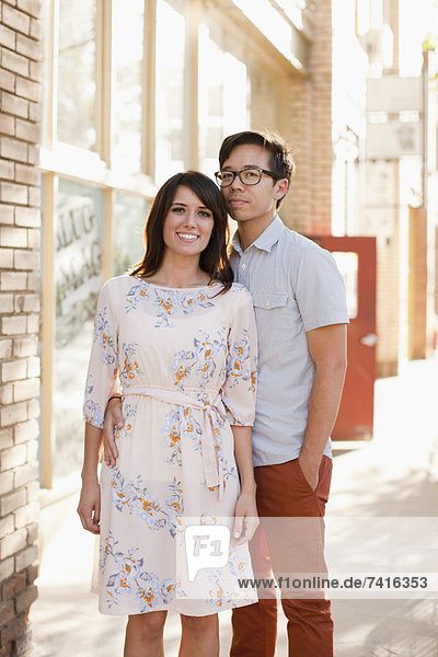 Portrait of couple standing on sidewalk
