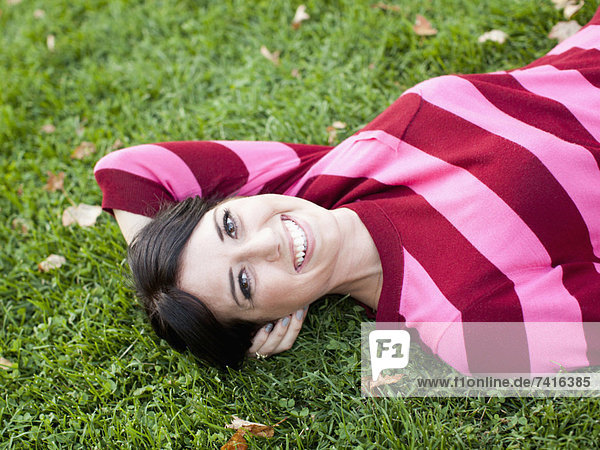 Portrait einer Frau auf Gras liegend