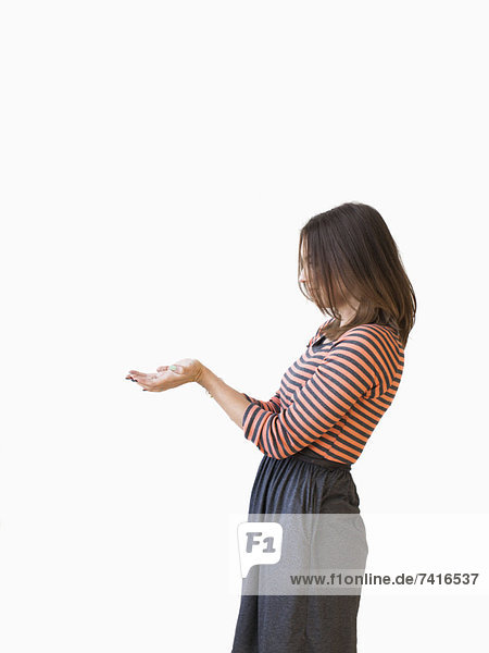 Studio shot young woman bending over backwards pretending like holding something