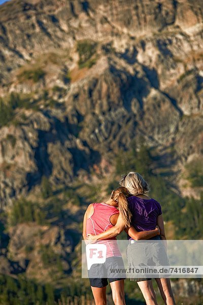 A mother and daughter share a tender moment and soak in the beauty on a Summer hiking adventure.