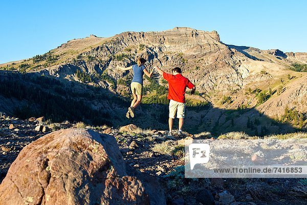 A couple enjoys a playful moment on a hiking adventure.
