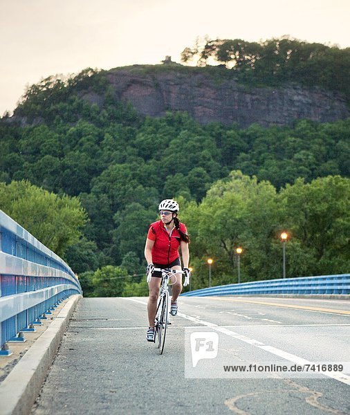 A female cyclist rides over a bridge in western Massachusetts.
