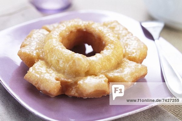 A Glazed Doughnut on a Purple Plate
