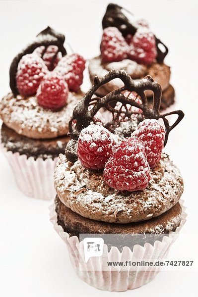 Schokoladen-Cupcakes mit Himbeeren und Schoko-Ornament