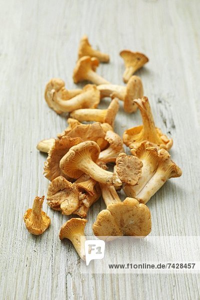 Fresh chanterelle mushrooms on a wooden surface