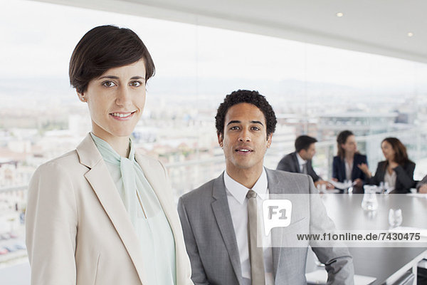 Portrait des lächelnden Geschäftsmannes und der Geschäftsfrau im Konferenzraum