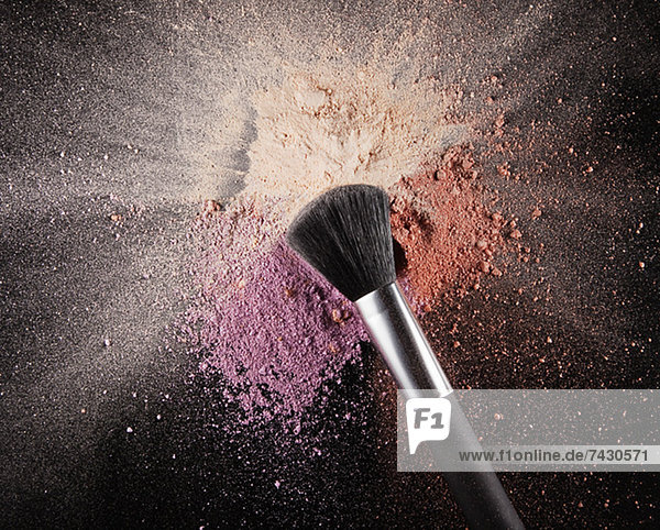 Makeup brush over multicolor blush splatter