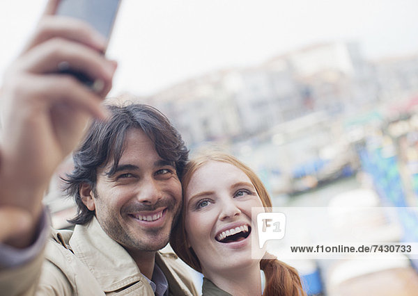 Lächelndes Paar beim Selbstporträt mit Handy