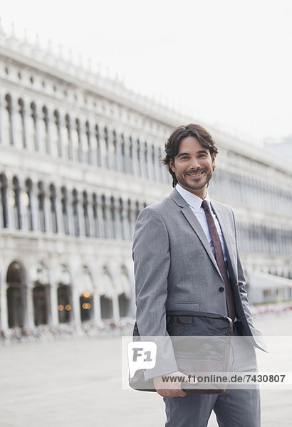 Porträt des lächelnden Geschäftsmannes auf dem Markusplatz in Venedig