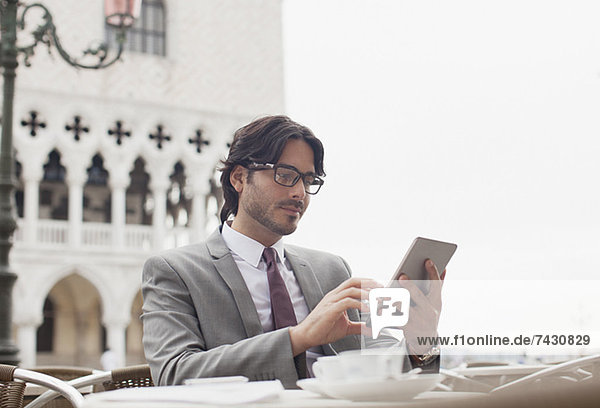 Geschäftsmann mit digitalem Tablett im Straßencafé in Venedig