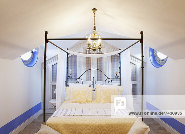 Kronleuchter über vier Plakatbetten im Luxus-Schlafzimmer
