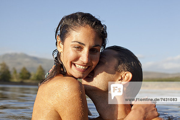 Nahaufnahme Porträt eines Paares  das sich im See küsst.