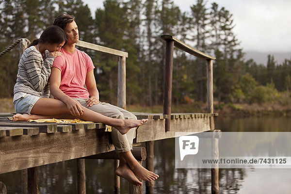 Ein ruhiges Paar sitzt am Ufer des Sees.