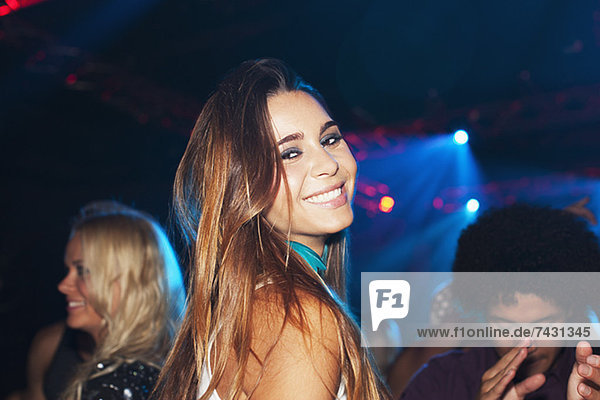 Porträt der lächelnden Frau auf der Tanzfläche des Nachtclubs