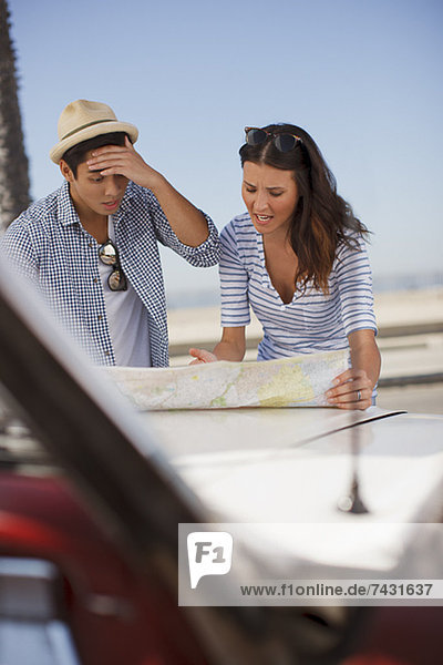 Frustriertes Paar beim Lesen der Straßenkarte