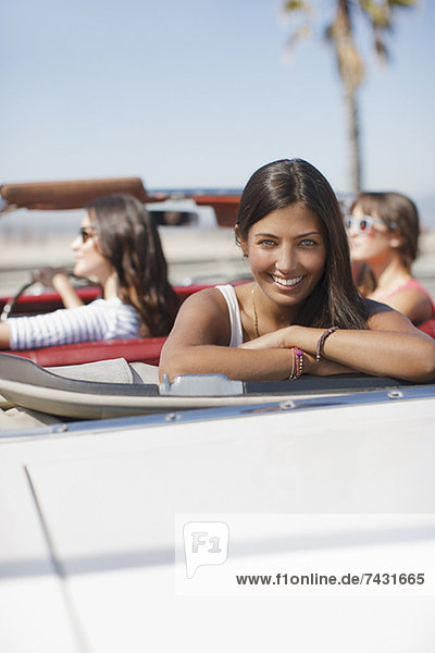 Lächelnde Frau im Cabrio sitzend