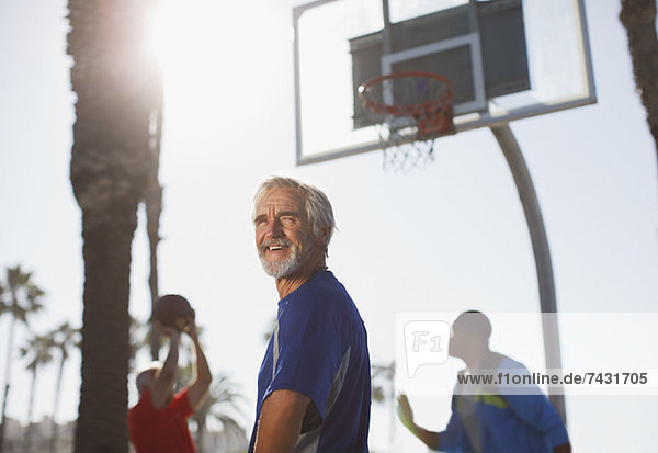 Ältere Männer spielen Basketball auf dem Platz