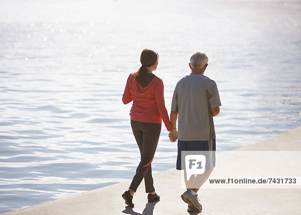 Older couple walking together on beach