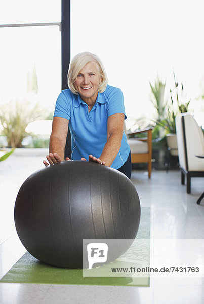 Ältere Frau mit Übungsball zu Hause