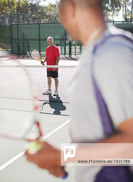 Ältere Männer beim Tennisspielen auf dem Platz