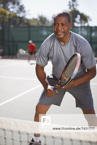 Älterer Mann beim Tennisspielen auf dem Platz