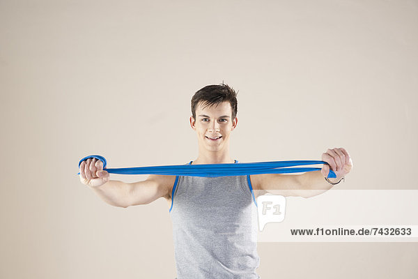 junger Mann macht Übungen mit einem Gymnastikband