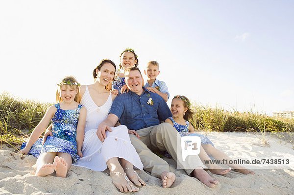 Caucasian family sitting together on beach