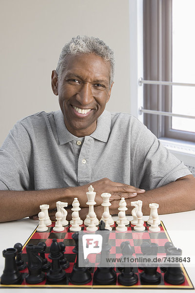 Smiling mixed race man playing chess