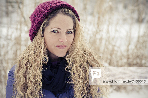Blonde Frau in Winterkleidung im Freien  Portrait