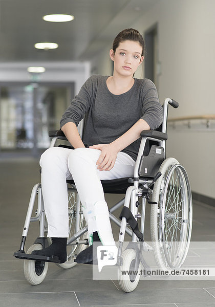 Junge Patientin sitzt im Rollstuhl
