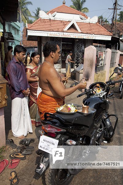 Priest blessing a new motorcycle outside a temple in Kochi (Cochin)  Kerala  India  Asia