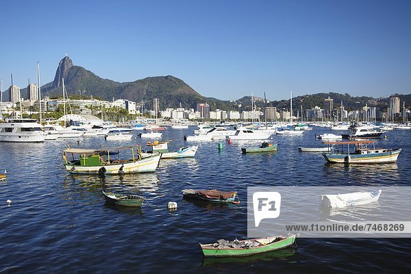 Boats moored in the harbour with Christ the Redeemer statue in background  Urca  Rio de Janeiro  Brazil  South America