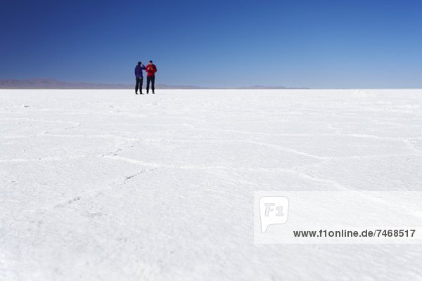 Couple taking photos on Salar de Uyuni (Salt Flats of Uyuni)  Potosi Department  Bolivia  South America