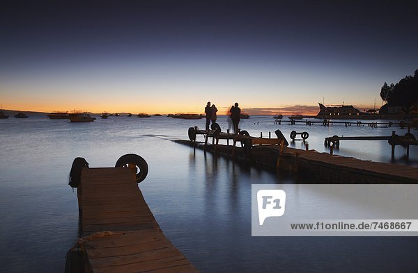 People standing on pier at sunset  Copacabana  Lake Titicaca  Bolivia  South America