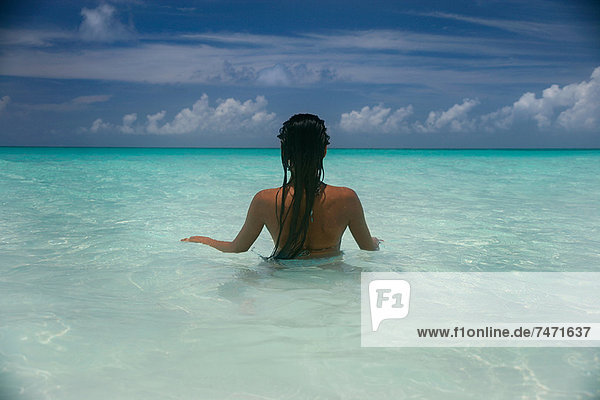 Frau im tropischen Wasser stehend