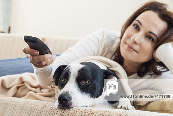 Woman watching television with dog