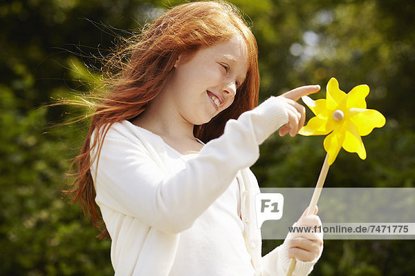 Girl playing with pinwheel outdoors