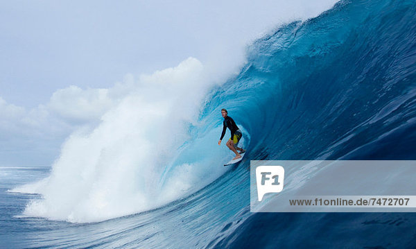 Man surfing in curl of wave