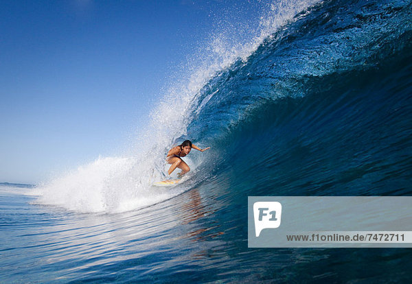 Woman surfing in crest of wave